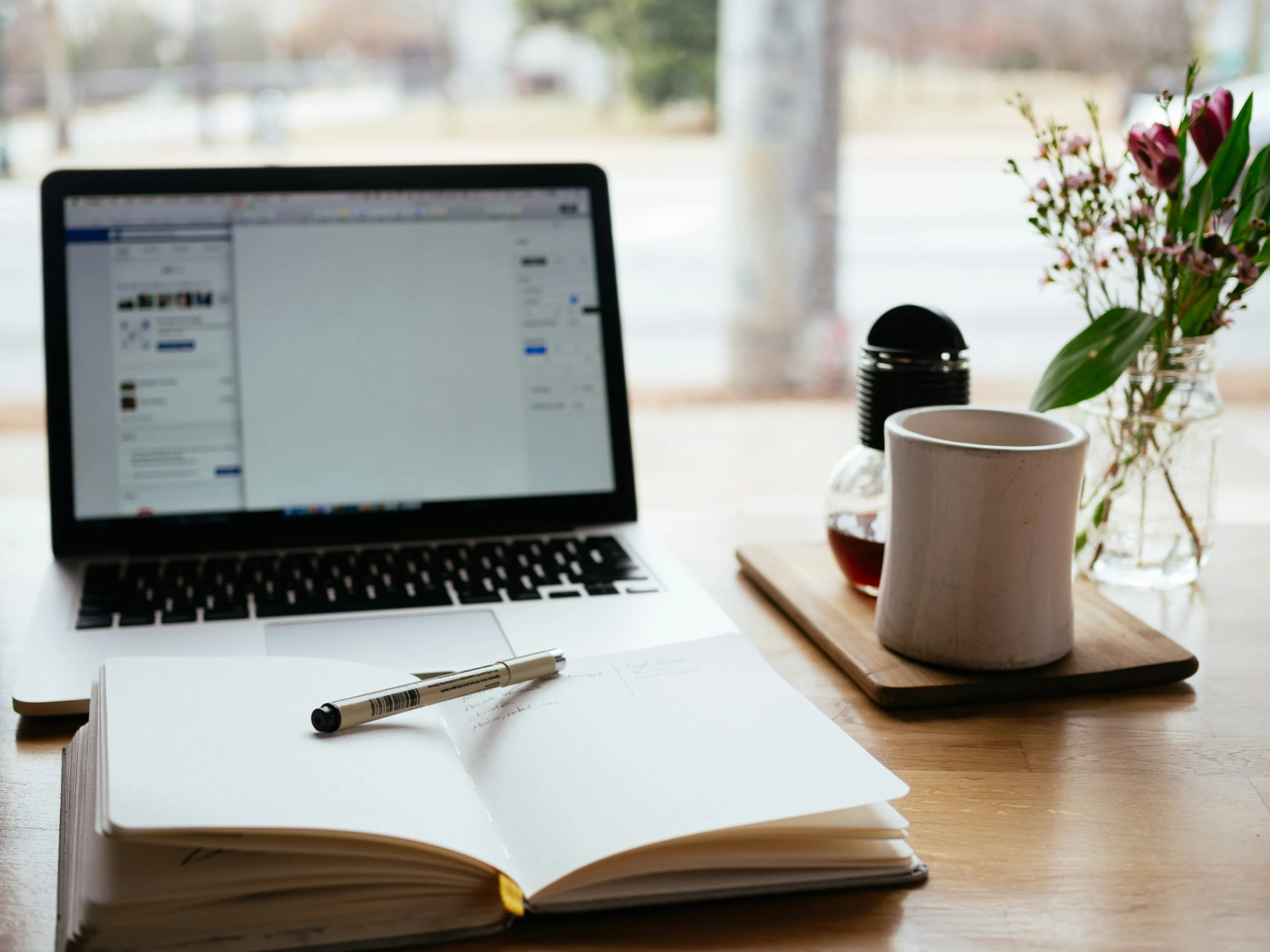 Vrouw die met een laptop op schoot aan een bureau werkt in een lichte en moderne kantooromgeving