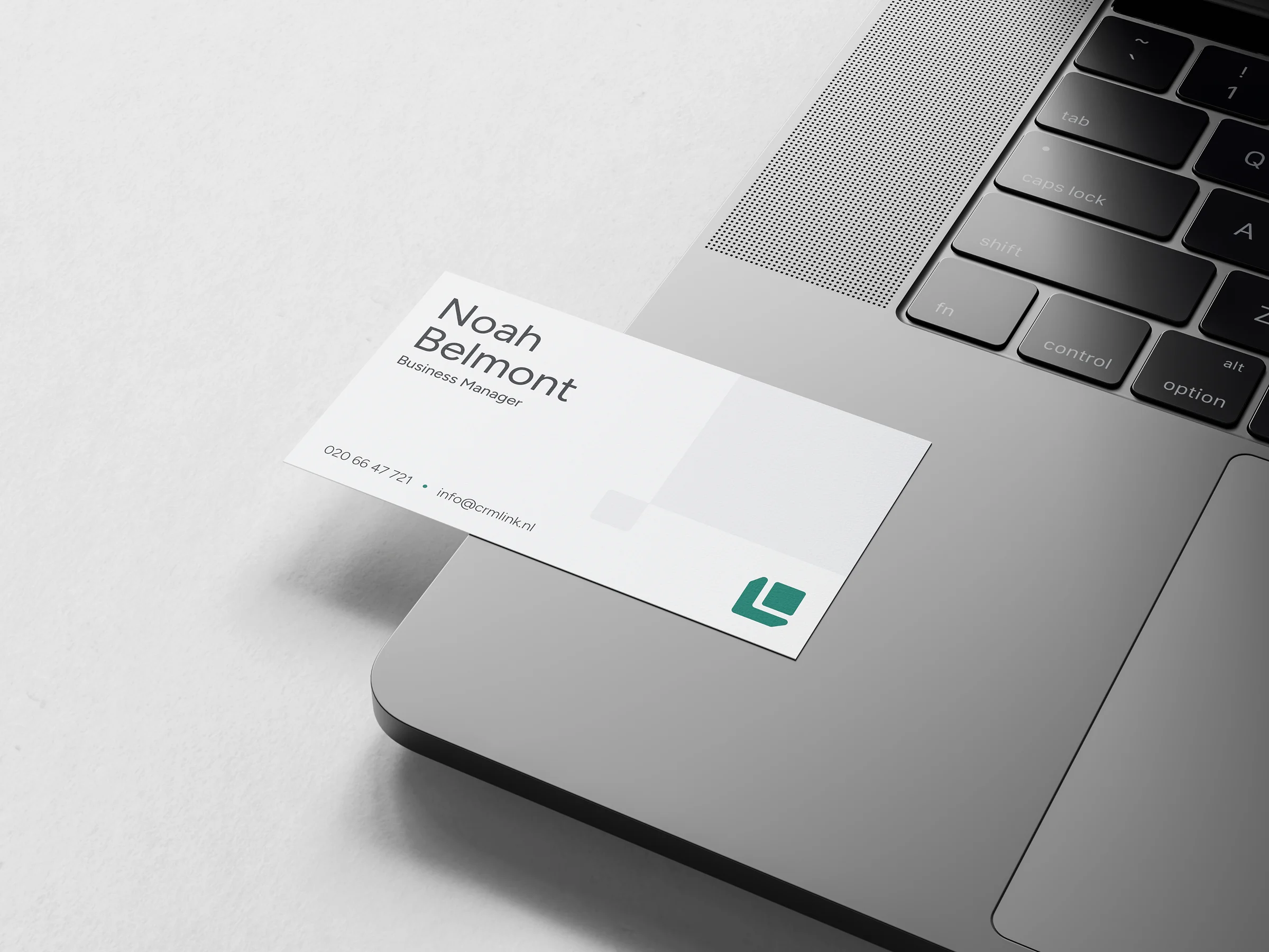 Visitekaartje met naam Noah Belmont, titel Business Manager, telefoonnummer en e-mail op laptop